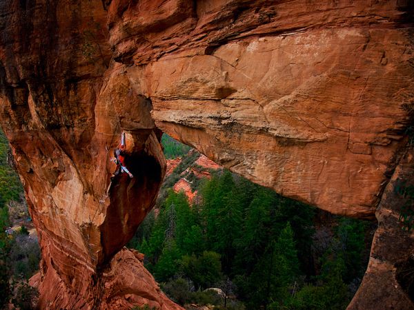 Photo: Climber dangling from red rock